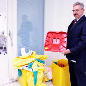 Abfallbeauftragter Hans Peter Kiefler vor einem Sammelbehälter. Deutlich zu sehen: Die kleine gelbe Öffnung im Behälterdeckel, durch die der Dampf beim Autoklavieren einströmen kann. (Foto: Abfallmanager Medizin)