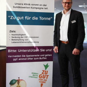 Verwaltungsleiter Tobias Schuchardt ist ausgebildeter Klimamanager. Im Rahmen des Projekts KLIK green wird bereits vor dem Speisesaal auf die Kampagne "Zu gut für die Tonne!" hingewiesen (Foto: Abfallmanager Medizin)