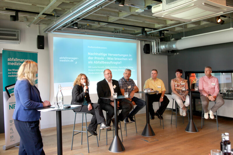 Im Podium stellen sich unsere Expertinnen und Experten den Fragen unserer Moderatorin Katrin Sturm und der Teilnehmenden: Lucia Donath, Heiko Schlüter, Hans Peter Kiefler, Roland Dittmann, Silvia Hermes und Christian Heintzmann (v.l.n.r.). (Foto: Abfallmanager Medizin)