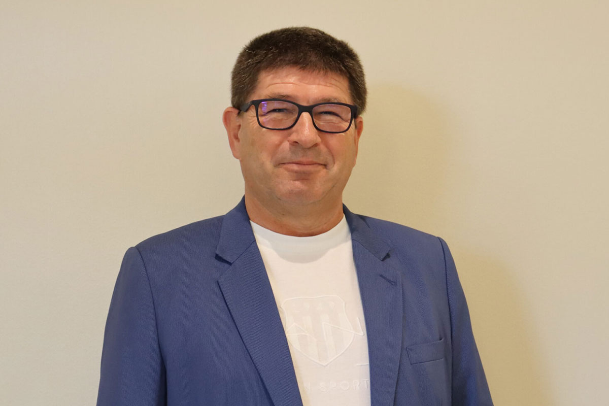 Mann im blauen Sakko vor einer hellen Wand. (Foto: AM)