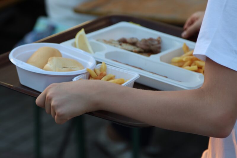 Person trägt Tablett mit Speisen in Einwegverpackungen (Foto: Angelo F- )