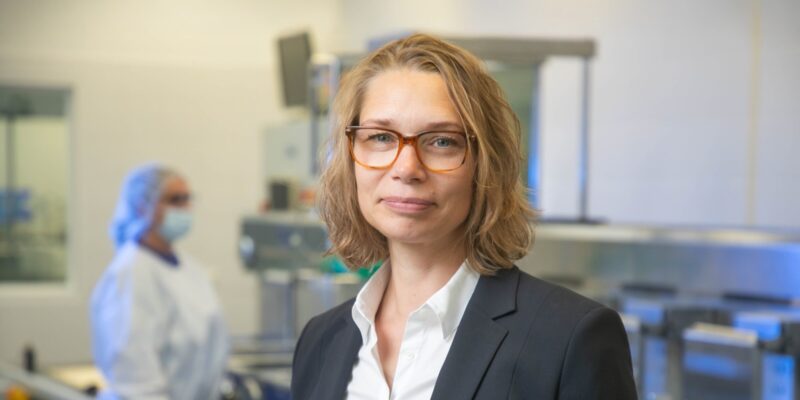 Frau in Businessoutfit, im Hintergrund Labor (Bild: Christian Kielmann)