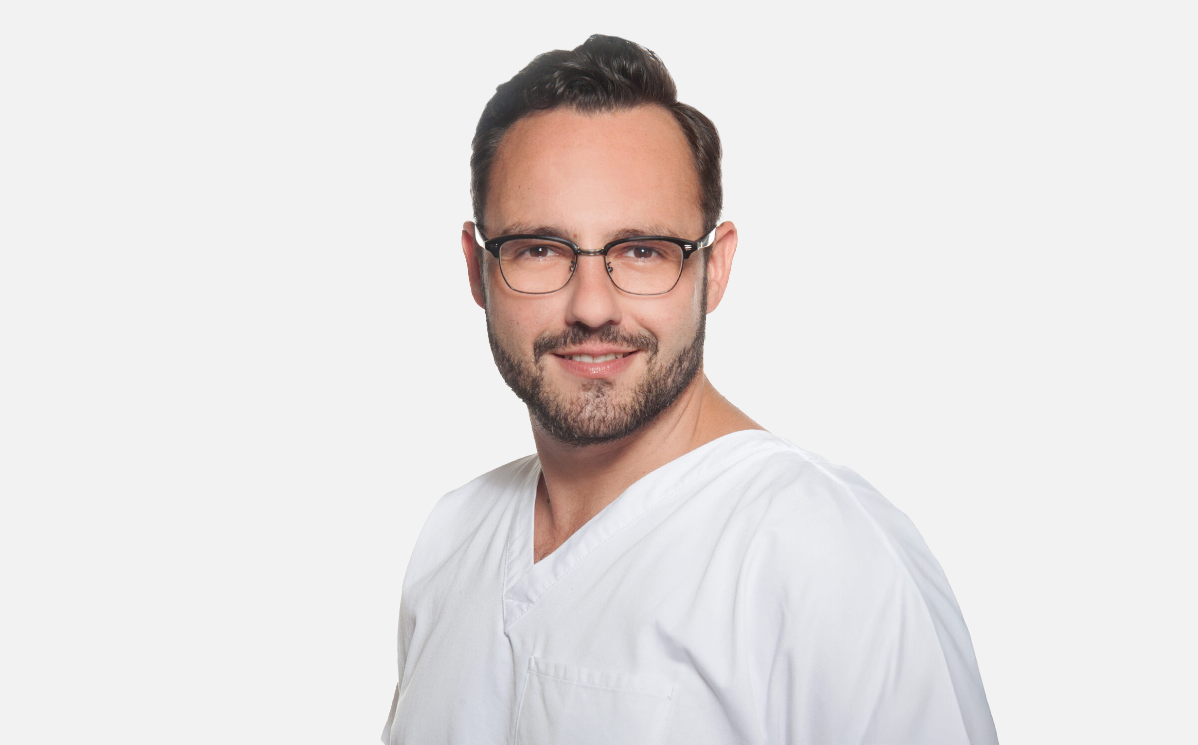 Mann in weißer medizinischer Kleidung vor weißem Hintergrund.