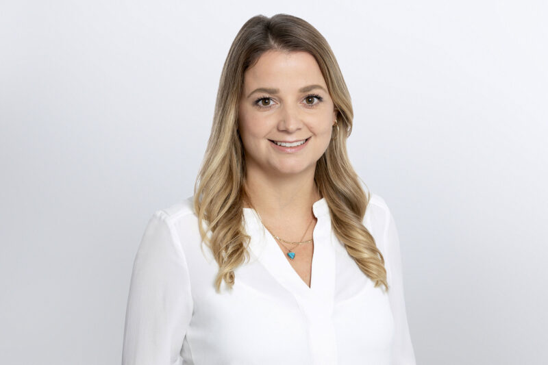 Frau in weißer Bluse vor grauem Hintergrund