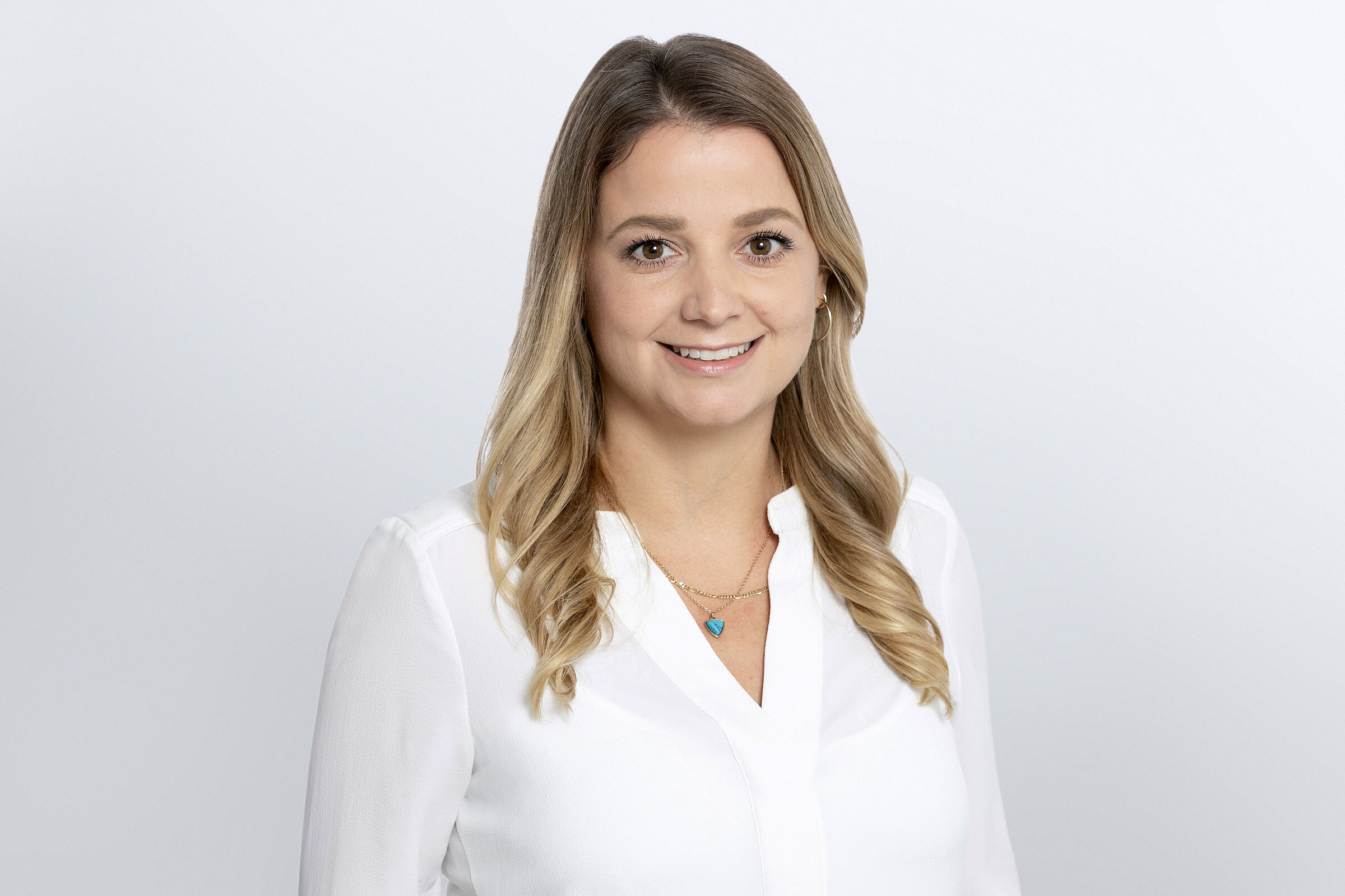 Frau in weißer Bluse vor grauem Hintergrund